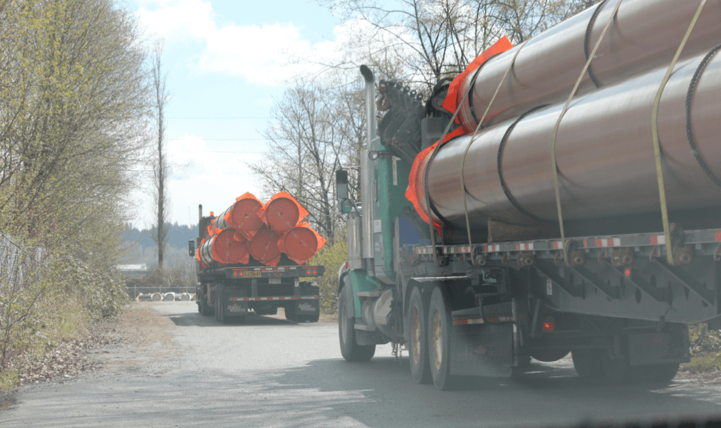 (Trucks are pictured carrying pipes travel into Kinder Morgan's New Westminster site. Contributed/Peter McCartney)