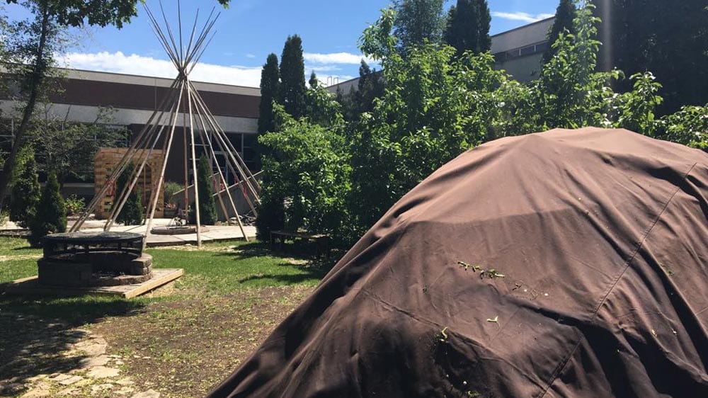 A sweat lodge sits in the foreground of the RB Russell school. Students smudge every morning. Photo: Brittany Hobson/APTN