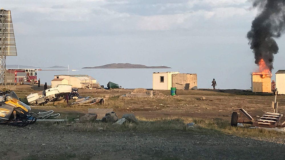 Homeless: Firefighters tackle a shack fire on the shore of Frobisher Bay in Iqaluit on July 19. (Qaumariaq Inuqtaqau photo)